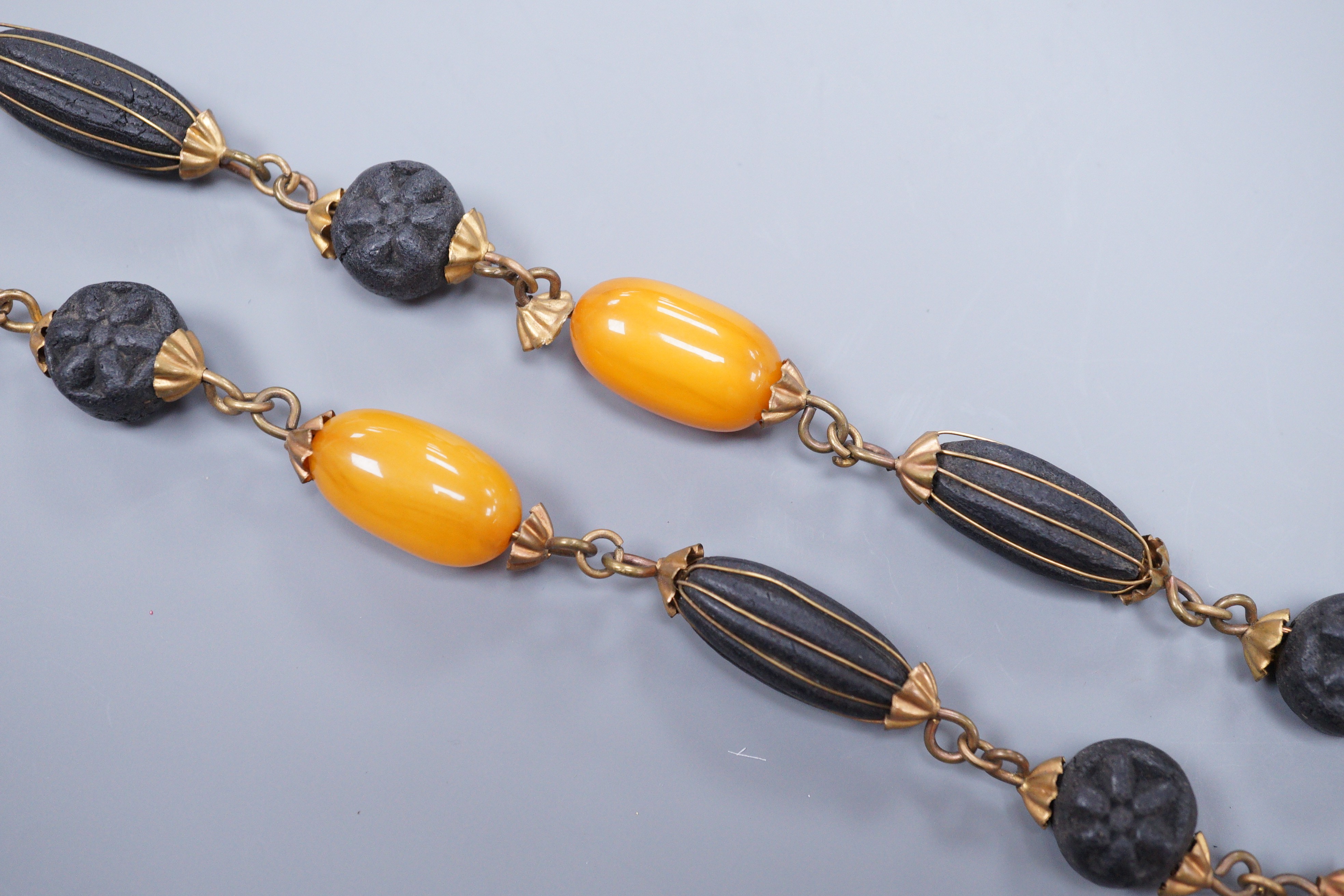 A 1930's gilt brass mounted composition and simulated amber bead necklace, 40cm